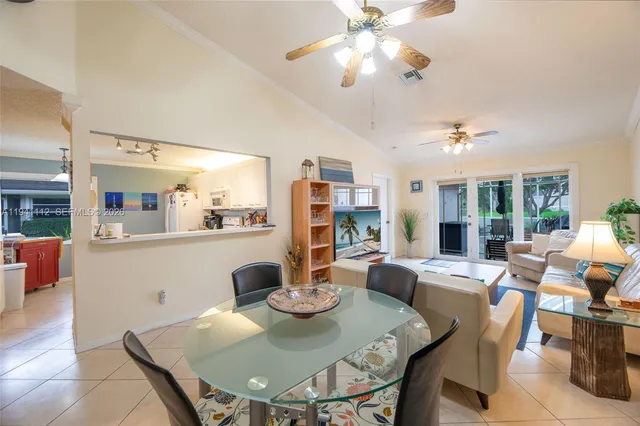 a view of a dining room with furniture a chandelier and large window