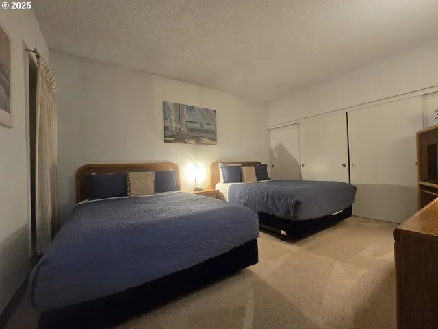 a bedroom with two beds and painting on the wall