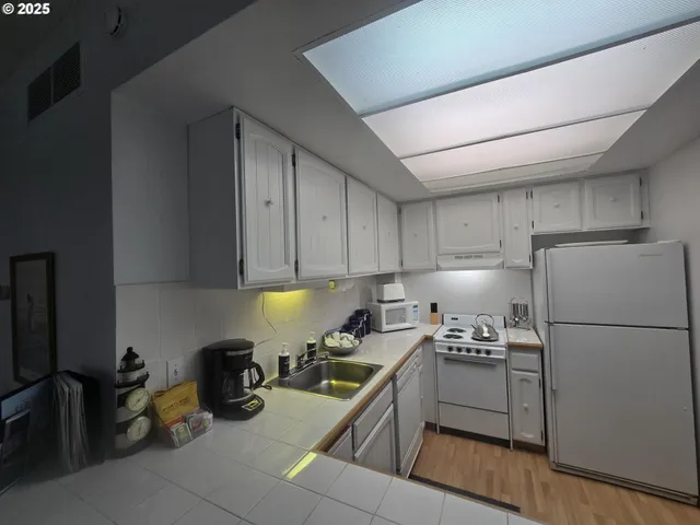 a kitchen with a refrigerator a stove a sink and cabinets
