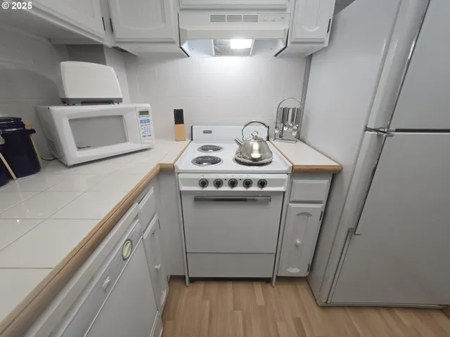 a white stove top oven sitting inside of a kitchen