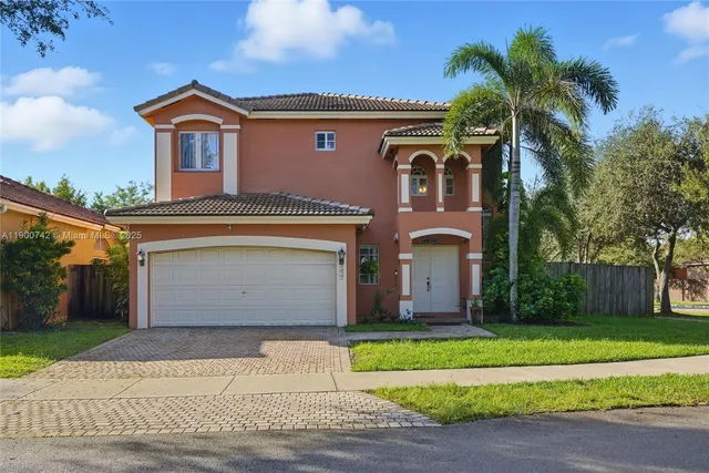 a front view of a house with a garden and garage