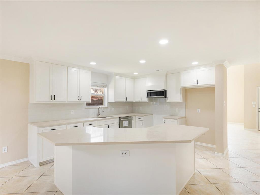 720 Pheasant Road Saginaw, TX 76131 - Photo 11 of 40 a kitchen with stainless steel appliances a sink stove and cabinets
