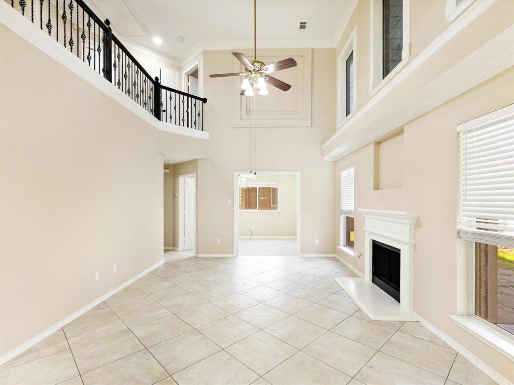 720 Pheasant Road Saginaw, TX 76131 - Photo 13 of 40 a view of a livingroom with a fireplace a ceiling fan and windows