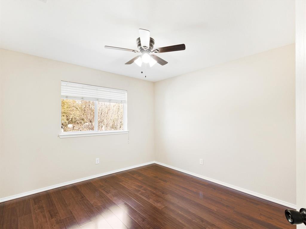 720 Pheasant Road Saginaw, TX 76131 - Photo 23 of 40 an empty room with wooden floor fan and windows
