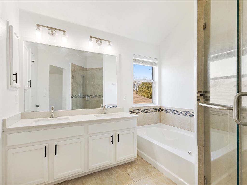 720 Pheasant Road Saginaw, TX 76131 - Photo 26 of 40 a bathroom with a bathtub a double vanity sink and mirror