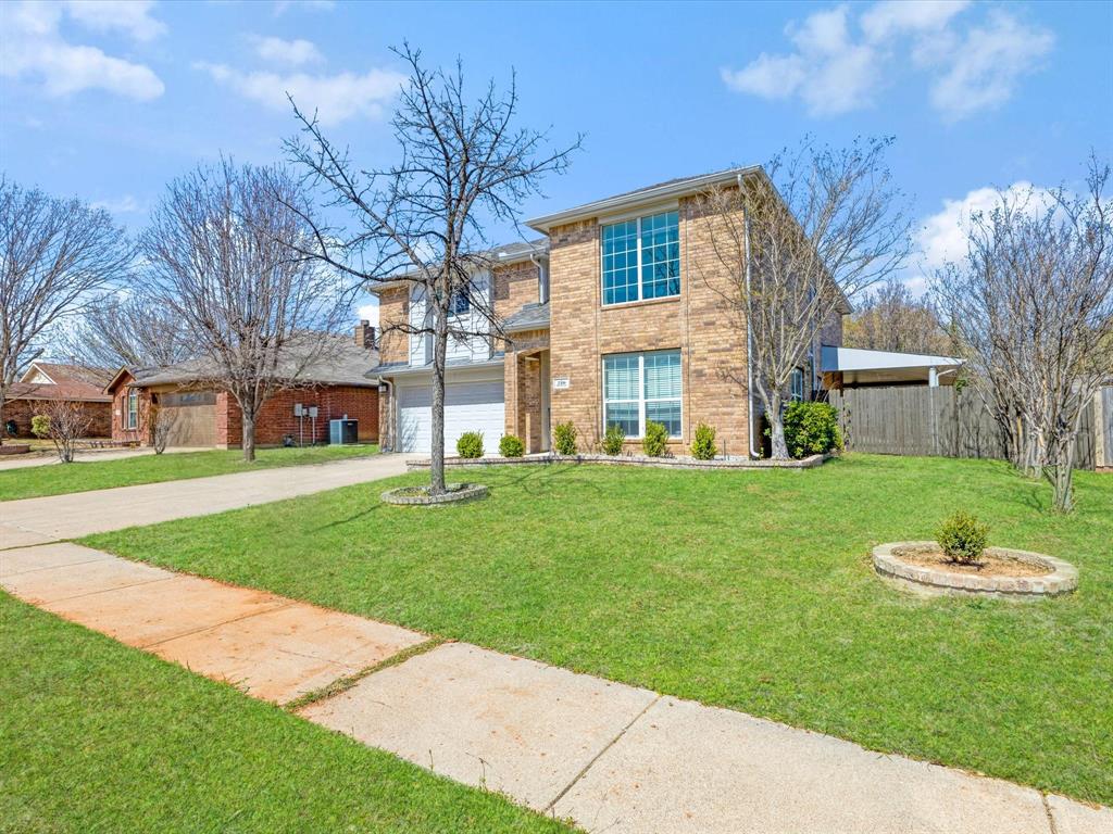 720 Pheasant Road Saginaw, TX 76131 - Photo 3 of 40 a front view of a house with a garden
