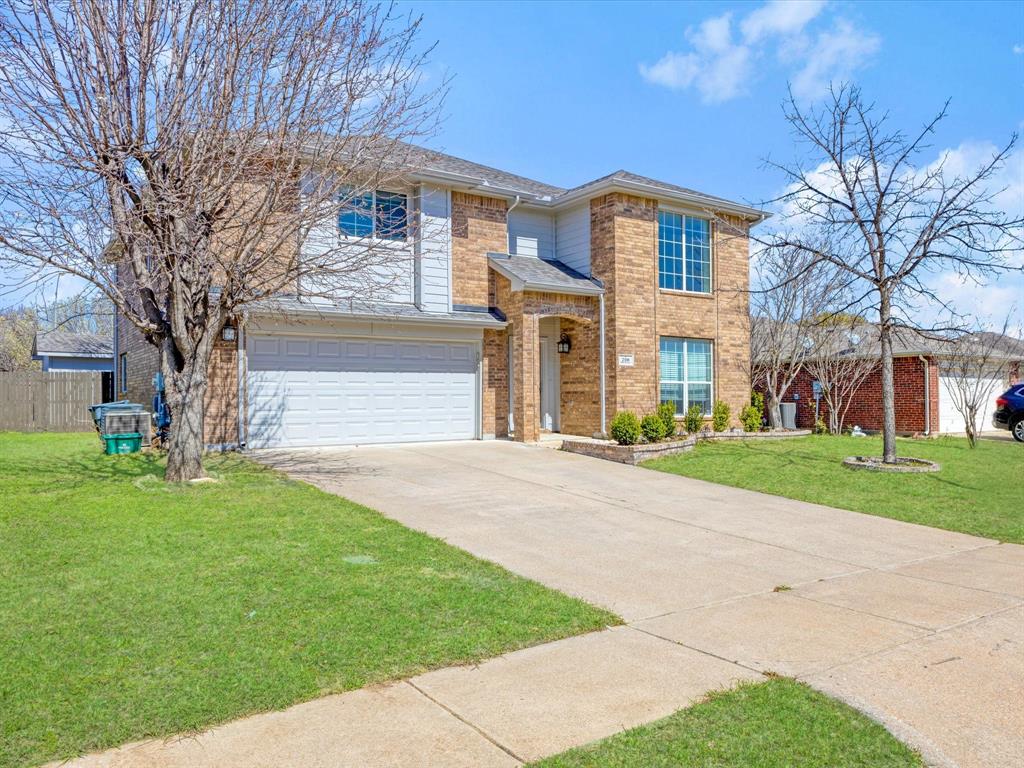 720 Pheasant Road Saginaw, TX 76131 - Photo 4 of 40 a front view of a house with a garden and trees