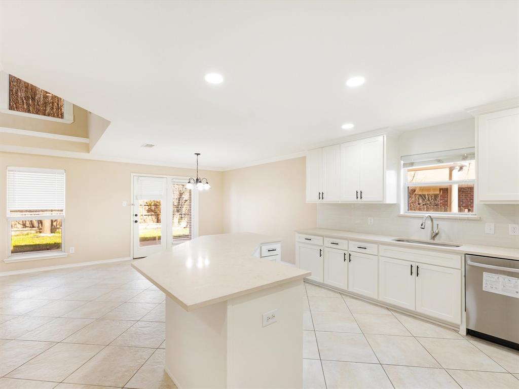 720 Pheasant Road Saginaw, TX 76131 - Photo 10 of 40 a large white kitchen with cabinets and wooden floor