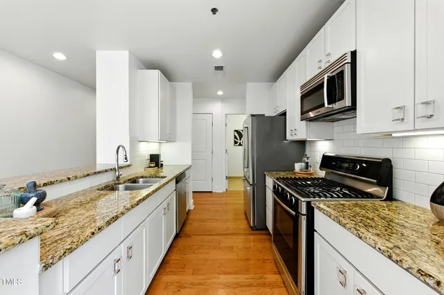 a kitchen with stainless steel appliances granite countertop a stove and a sink