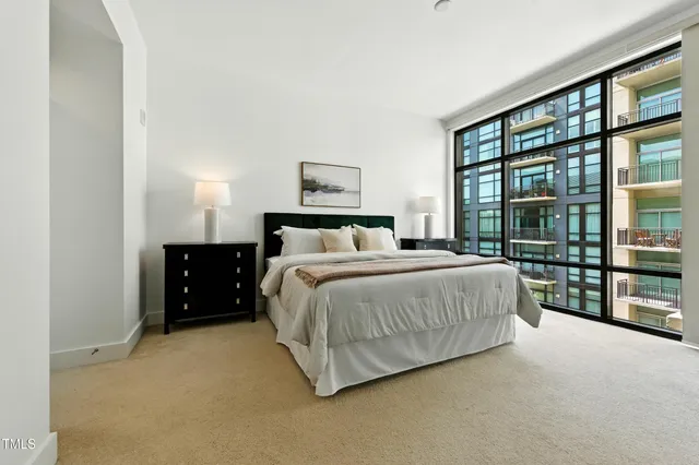 a spacious bedroom with a bed and a large window