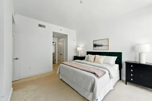 a large bed sitting in a bedroom and a lamp