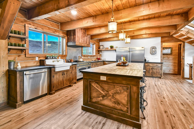 544 East 600 North, Unit 1 Joseph, UT 84739 - Photo 11 of 65 Kitchen featuring wood-finish flooring, exposed wood beams, wood cabinetry, a large kitchen island with a wood countertop, and stainless-steel appliances including a double-door refrigerator, dishwasher, and range