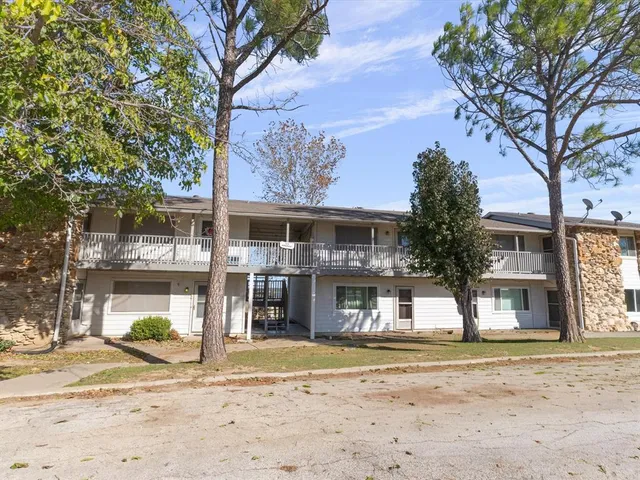 a front view of a house with a yard and trees