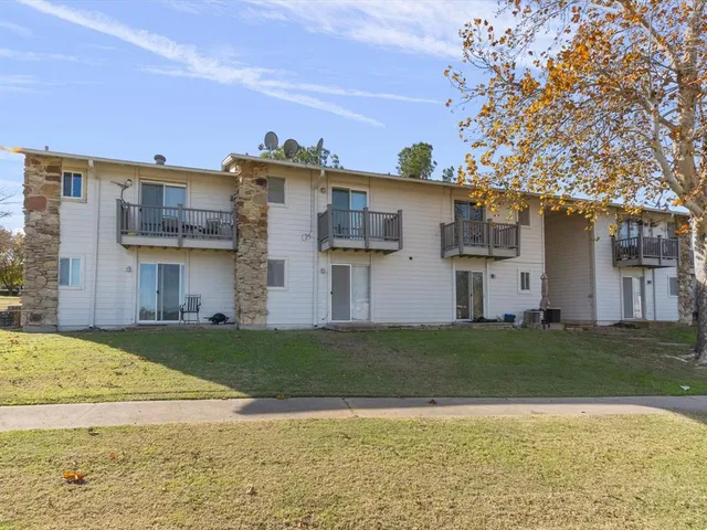 a view of a house with a yard and a tree