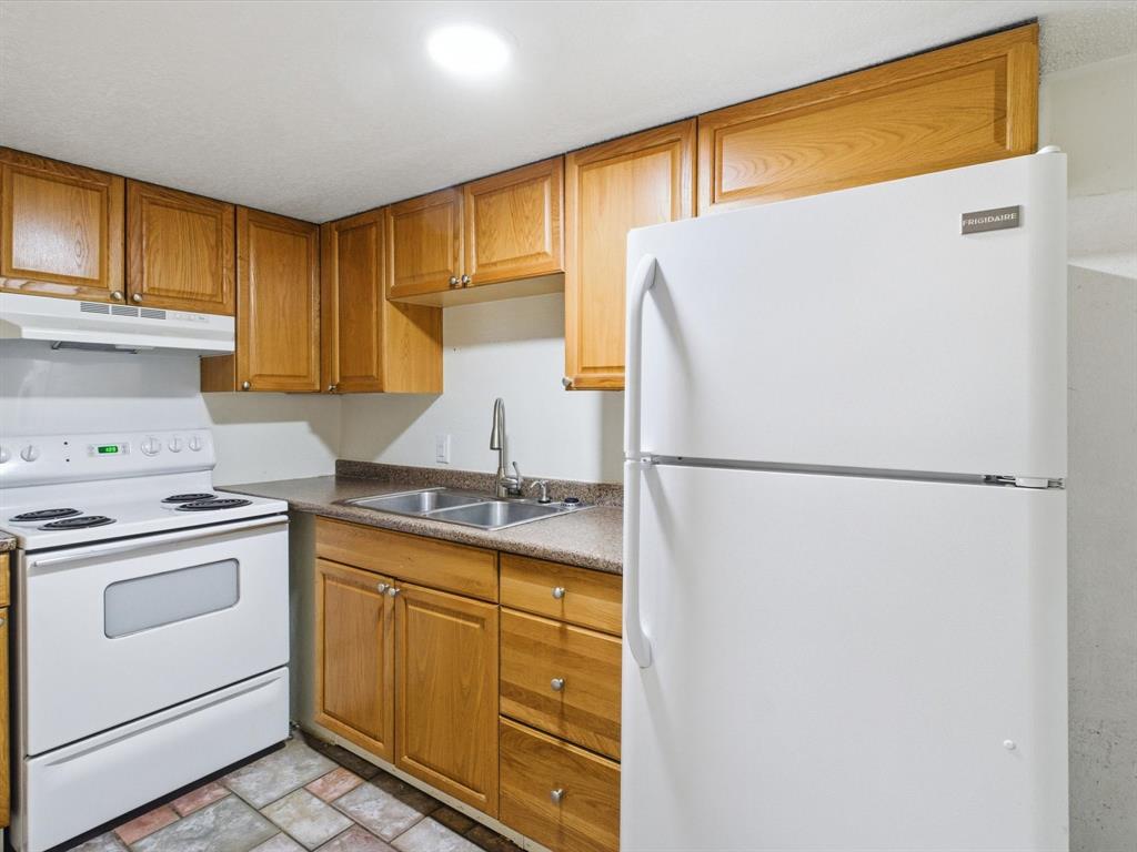 102 Harbor Drive, Unit 204 Runaway Bay, TX 76426 - Photo 7 of 17 a kitchen with a refrigerator sink stove and cabinets
