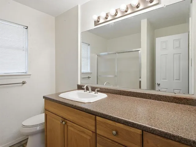 a bathroom with a sink a toilet and mirror