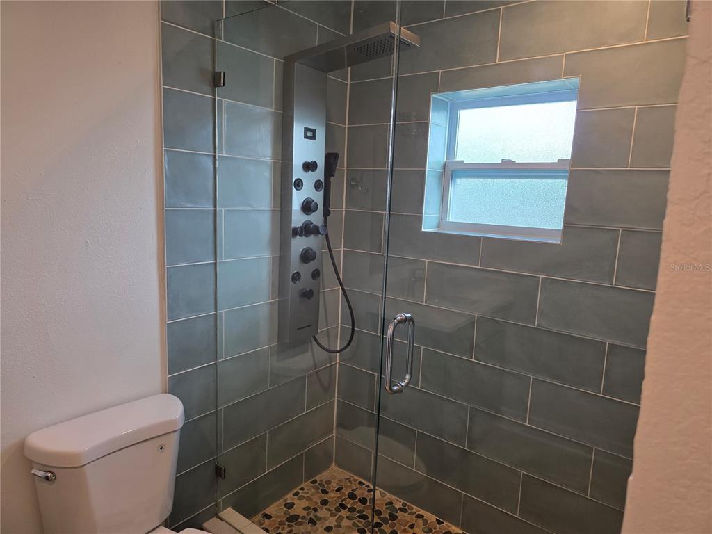 430 80th Way St. Pete Beach, FL 33706 - Photo 19 of 42 a bathroom with a toilet and a shower