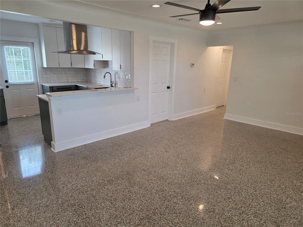 430 80th Way St. Pete Beach, FL 33706 - Photo 9 of 42 a kitchen with kitchen island white cabinets and stainless steel appliances