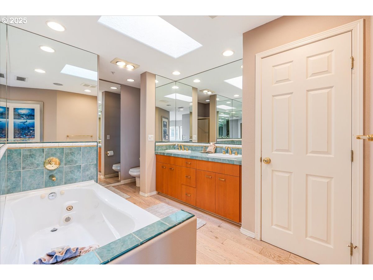 361 South Promenade, Unit 502 Seaside, OR 97138 - Photo 28 of 46 a bathroom with a tub a sink and a large mirror