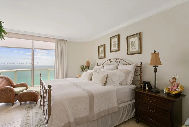 a bedroom with a bed and large windows