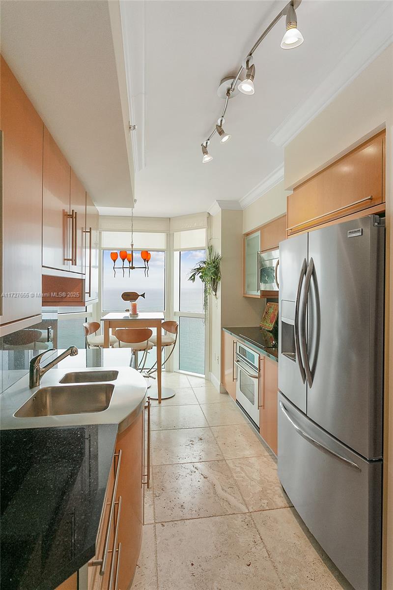 6365 Collins Avenue, Unit 3401 Miami Beach, FL 33141 - Photo 7 of 20 a kitchen with kitchen island a counter top space appliances and cabinets
