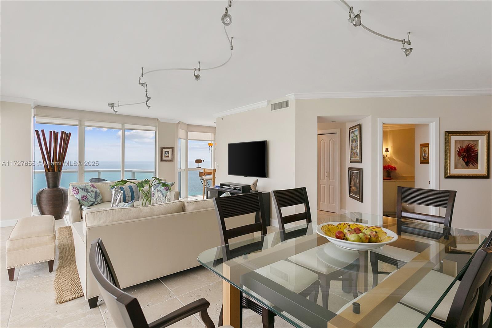 6365 Collins Avenue, Unit 3401 Miami Beach, FL 33141 - Photo 8 of 20 a living room with furniture and a flat screen tv