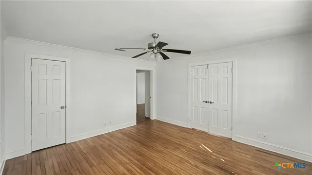 a view of empty room with wooden floor