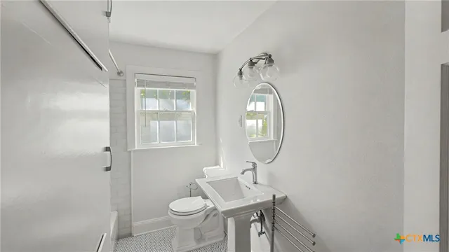 a bathroom with a toilet sink and mirror