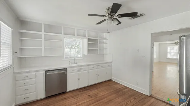 a kitchen with a refrigerator and white cabinets