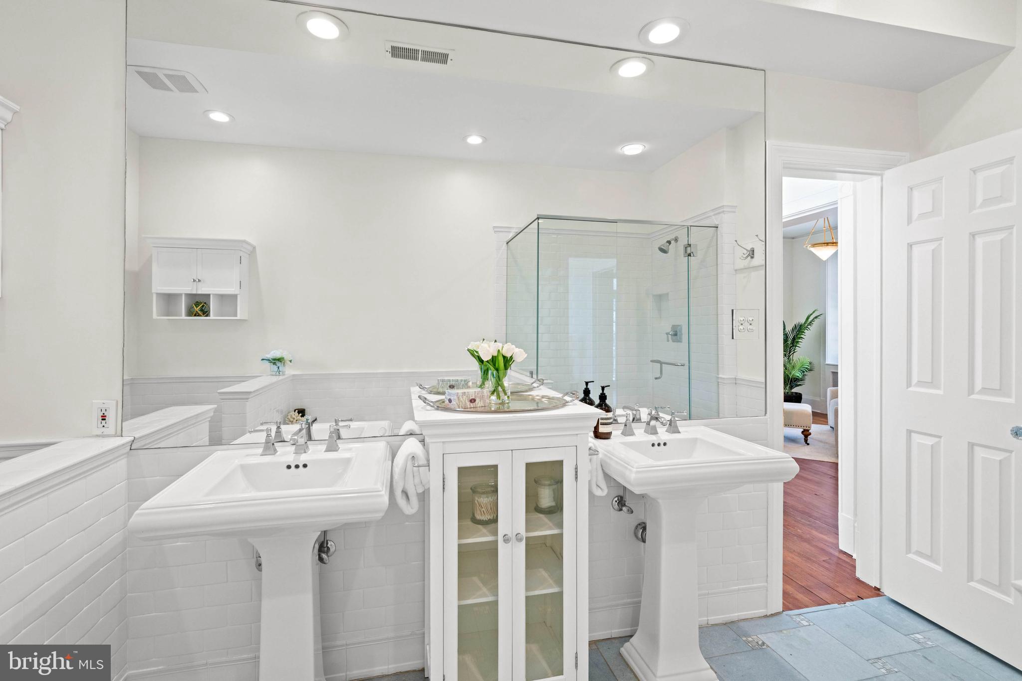 2325 Porter Street Northwest Washington, DC 20008 - Photo 24 of 50 a bathroom with a sink a mirror and a shower