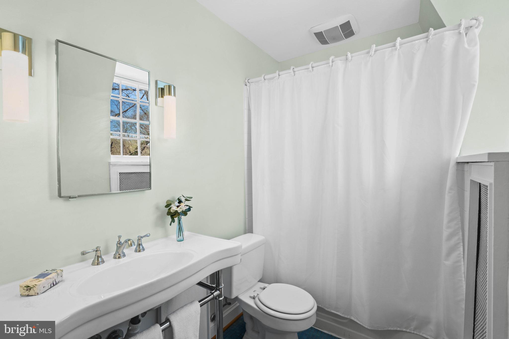 2325 Porter Street Northwest Washington, DC 20008 - Photo 34 of 50 a bathroom with a sink a toilet and shower curtain