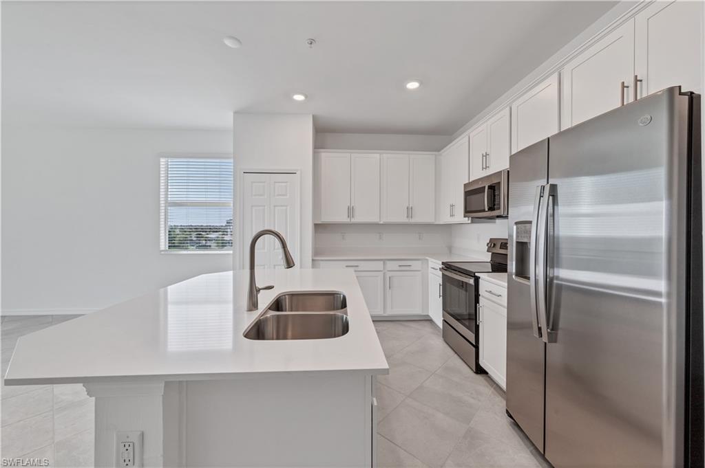43997 Boardwalk Loop, Unit 1838 Punta Gorda, FL 33982 - Photo 11 of 45 a kitchen with stainless steel appliances a refrigerator sink and cabinets