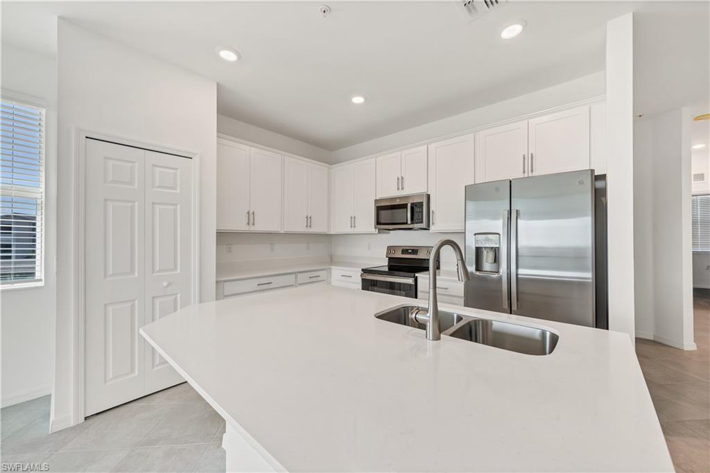 43997 Boardwalk Loop, Unit 1838 Punta Gorda, FL 33982 - Photo 13 of 45 a kitchen with kitchen island a counter top space cabinets stainless steel appliances and a window