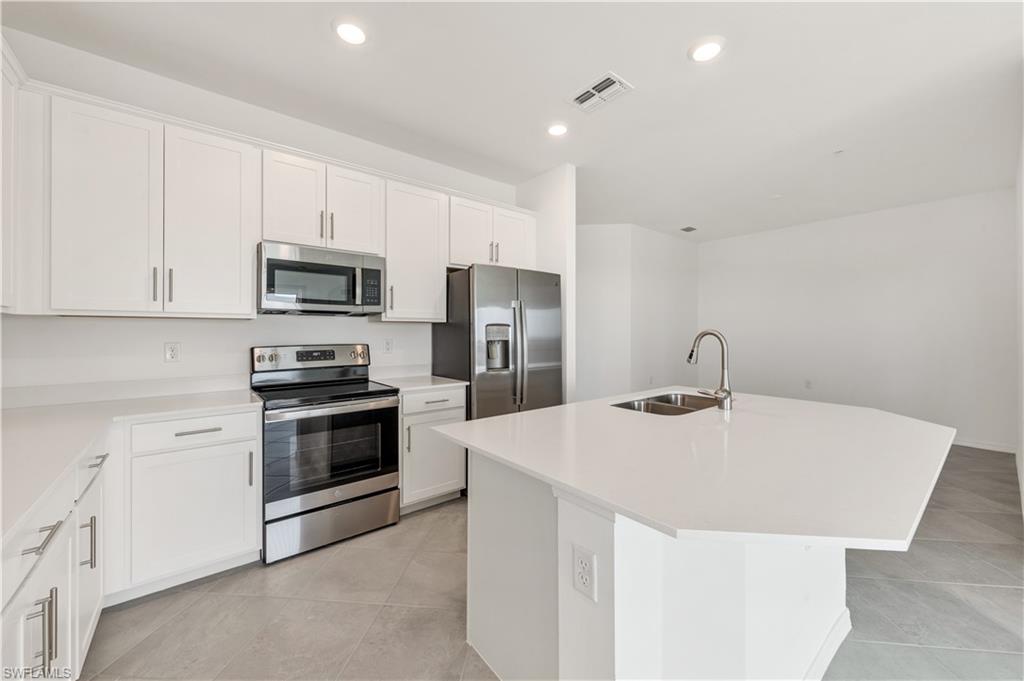43997 Boardwalk Loop, Unit 1838 Punta Gorda, FL 33982 - Photo 14 of 45 a kitchen with stainless steel appliances a stove microwave and sink
