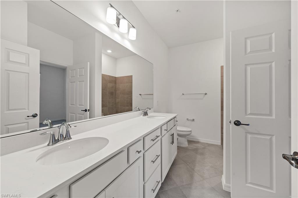 43997 Boardwalk Loop, Unit 1838 Punta Gorda, FL 33982 - Photo 33 of 45 a bathroom with a double vanity sink toilet and a mirror