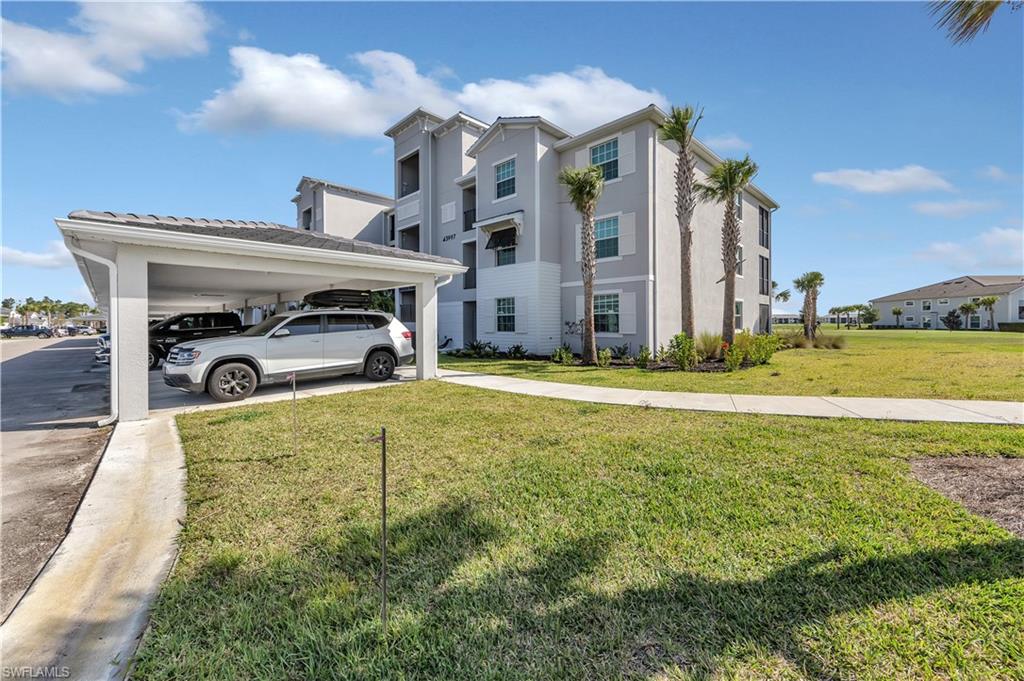 43997 Boardwalk Loop, Unit 1838 Punta Gorda, FL 33982 - Photo 9 of 45 a yellow building with trees in front of it