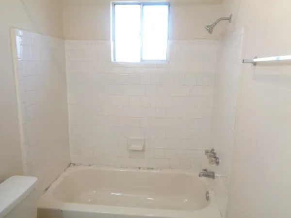 a bath tub sitting next to a white sink and a toilet