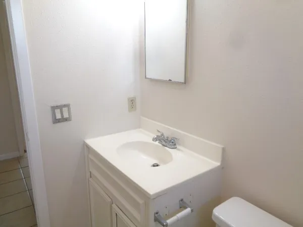a bathroom with a sink mirror and toilet