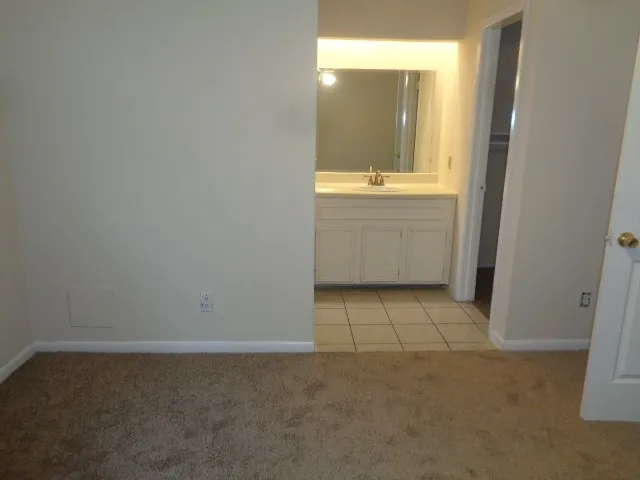view of an empty room with cabinet and mirror