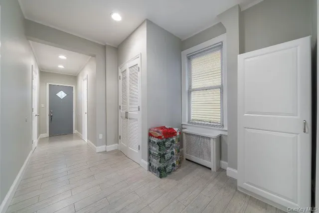 an empty room with wooden floor and hallway