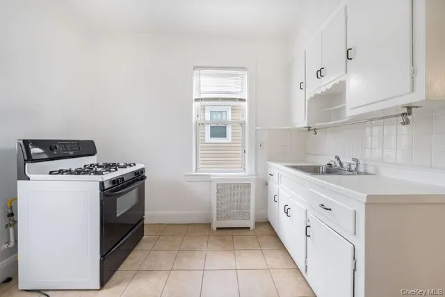 a kitchen with granite countertop white cabinets and white appliances