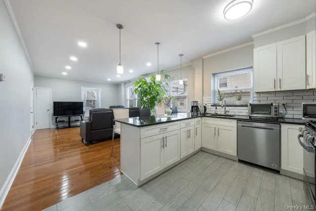 a kitchen with kitchen island granite countertop a sink cabinets and stainless steel appliances