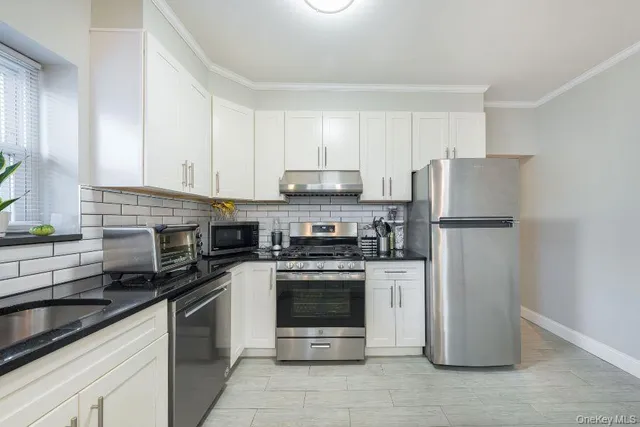 a kitchen with cabinets stainless steel appliances and a counter space