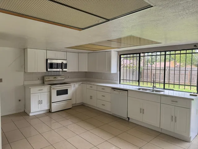 a kitchen with white cabinets and white appliances