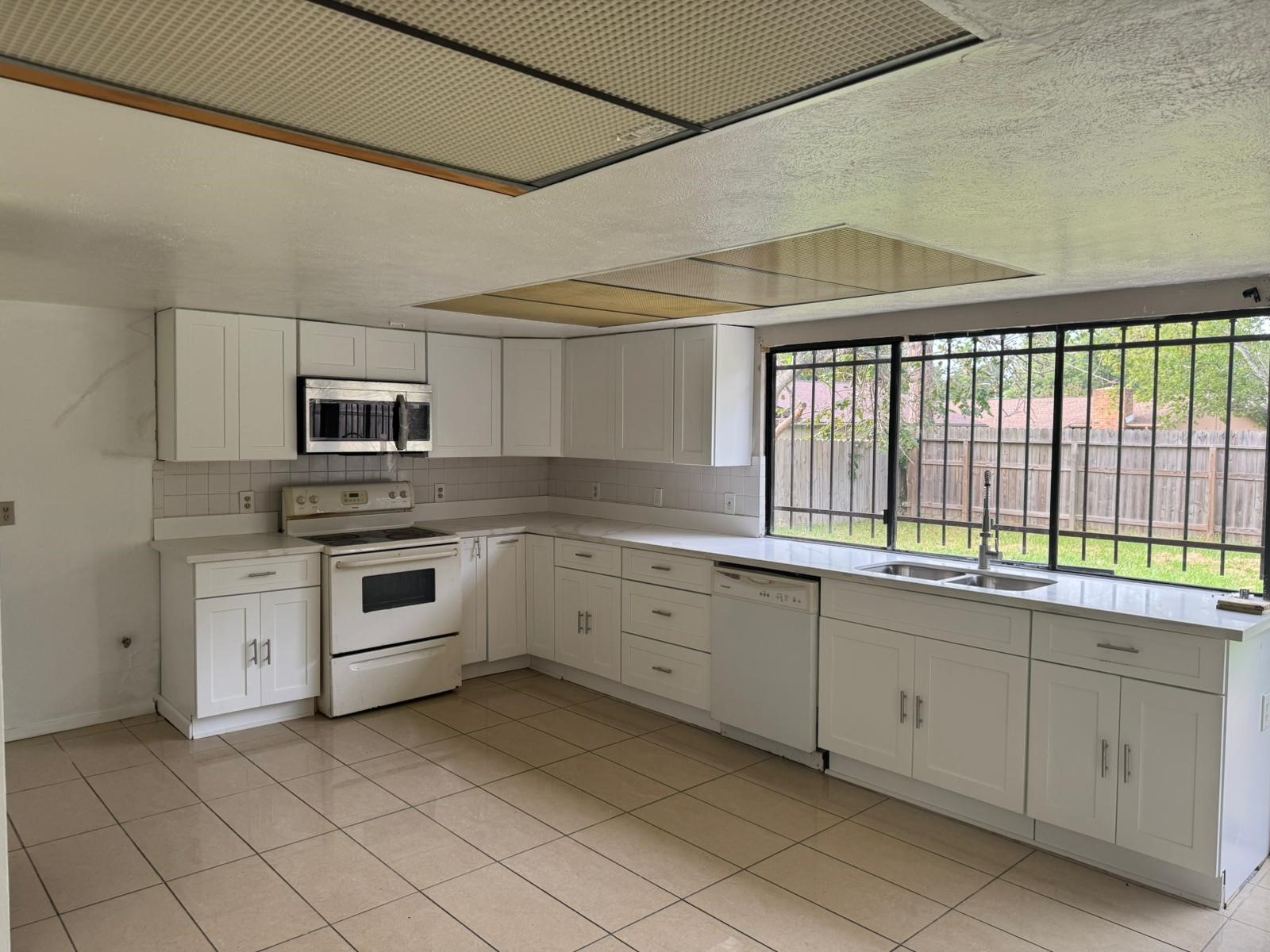 6110 West Ridgecreek Drive Houston, TX 77053 - Photo 3 of 13 a kitchen with white cabinets and white appliances