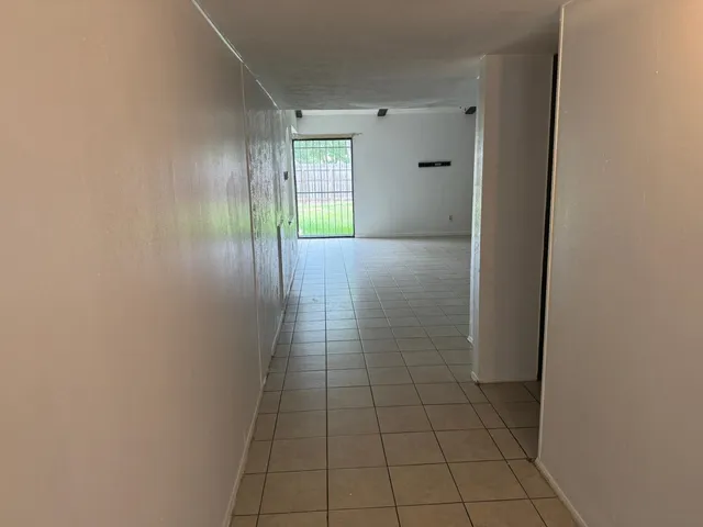 a view of an empty room with closet and a window
