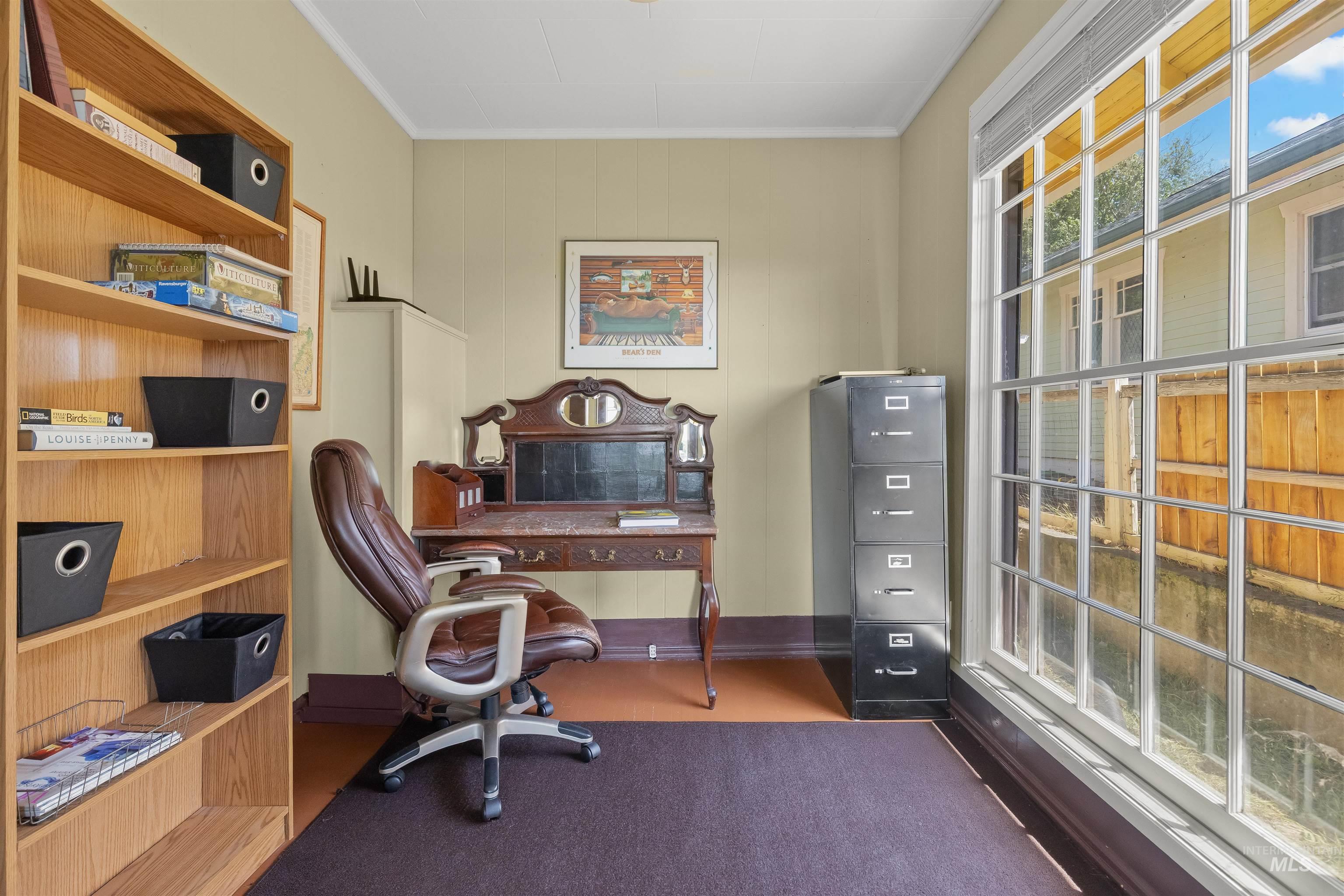 619 Prospect Avenue Lewiston, ID 83501 - Photo 10 of 37 Dedicated workspace featuring a large multi-pane window, light-colored walls, wood-finish flooring, and a built-in bookcase