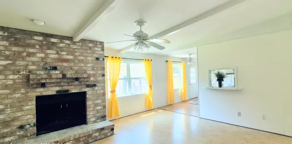 a view of an empty room with a fireplace and a window