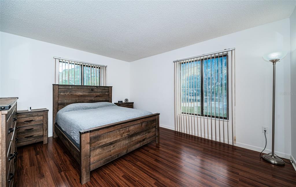 2522 Pine Ridge Way South, Unit A2 Palm Harbor, FL 34684 - Photo 13 of 34 a bedroom with a bed wooden floor and window