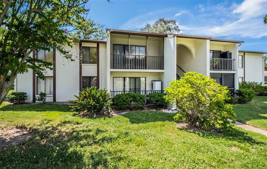 2522 Pine Ridge Way South, Unit A2 Palm Harbor, FL 34684 - Photo 2 of 34 a front view of a house with a yard